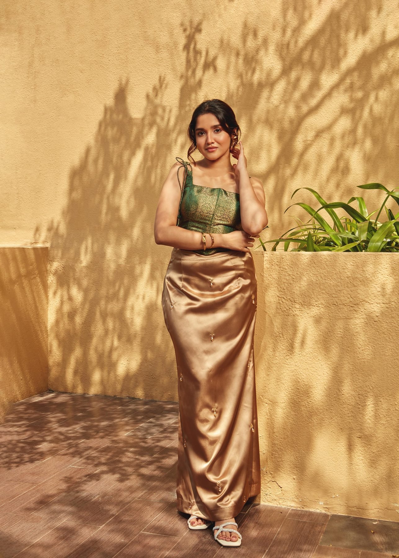 Anikha Surendran in green and gold satin in the warm courtyard light at The Westin Chennai